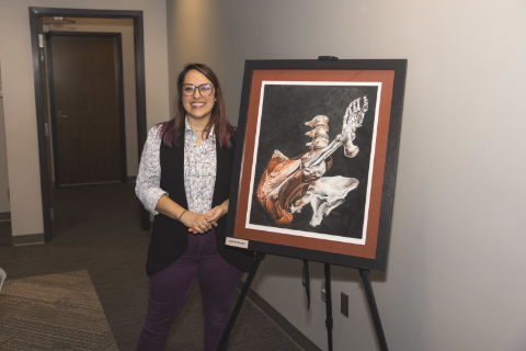 UWF student posing with her realistic illustration of human anatomy.